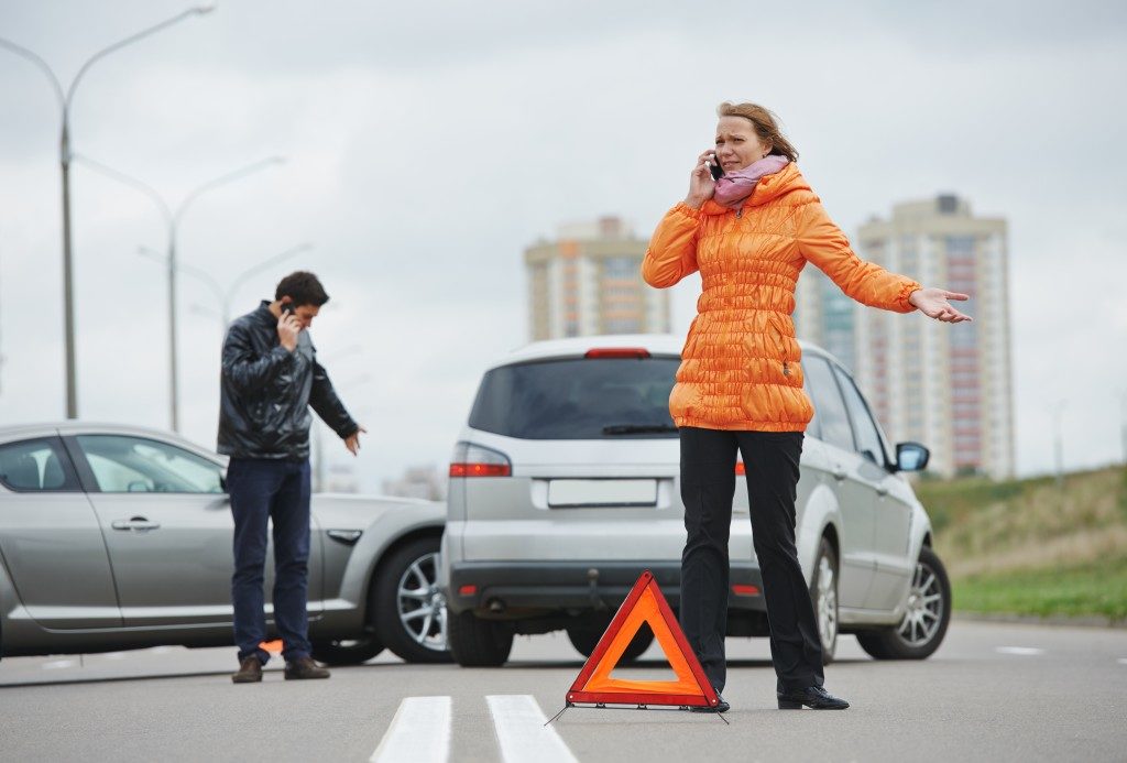 Man and woman calling after a car accident