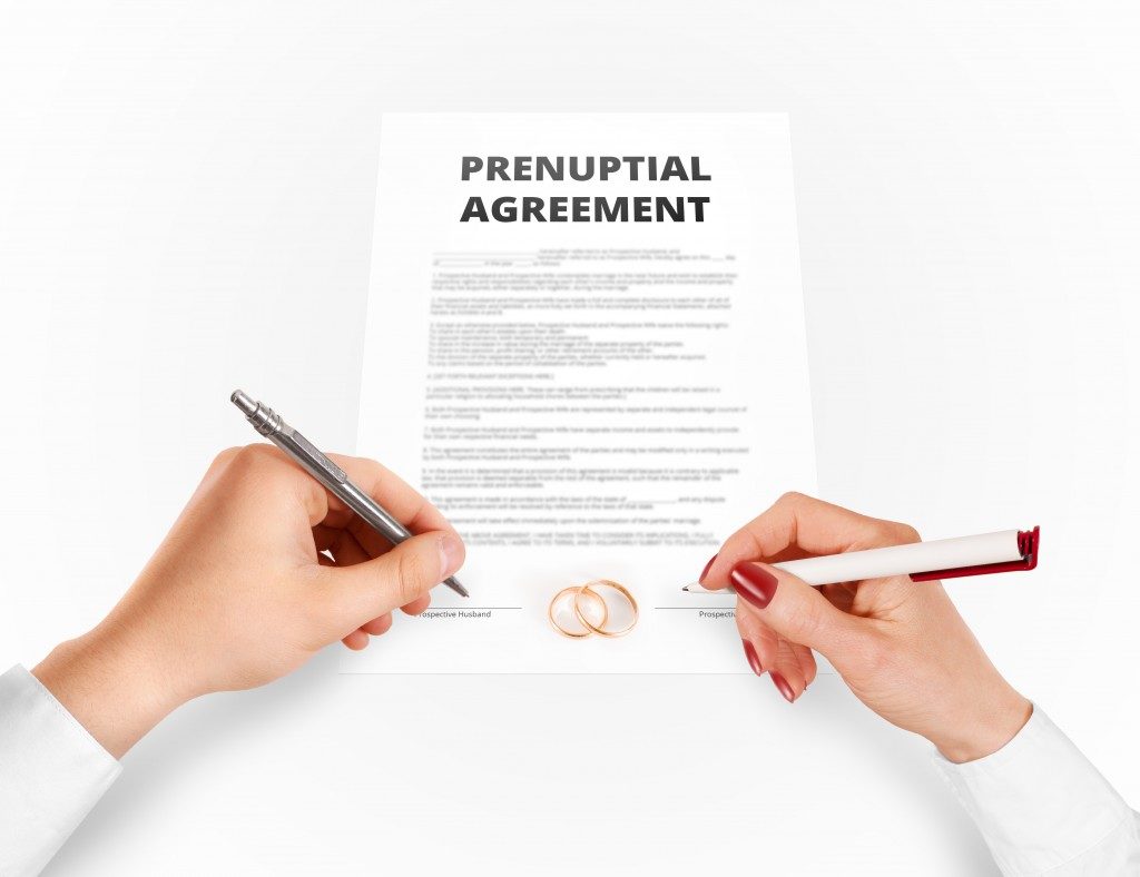 couple signing prenuptial agreement