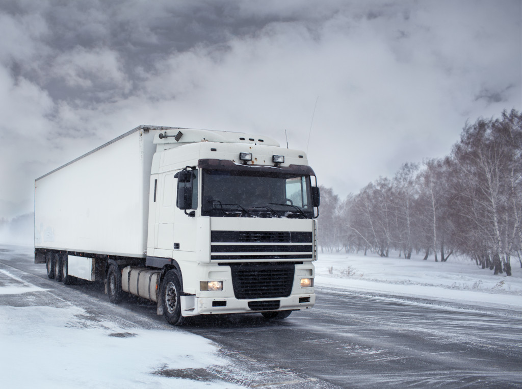 A large freight truck driving through a wintry highway