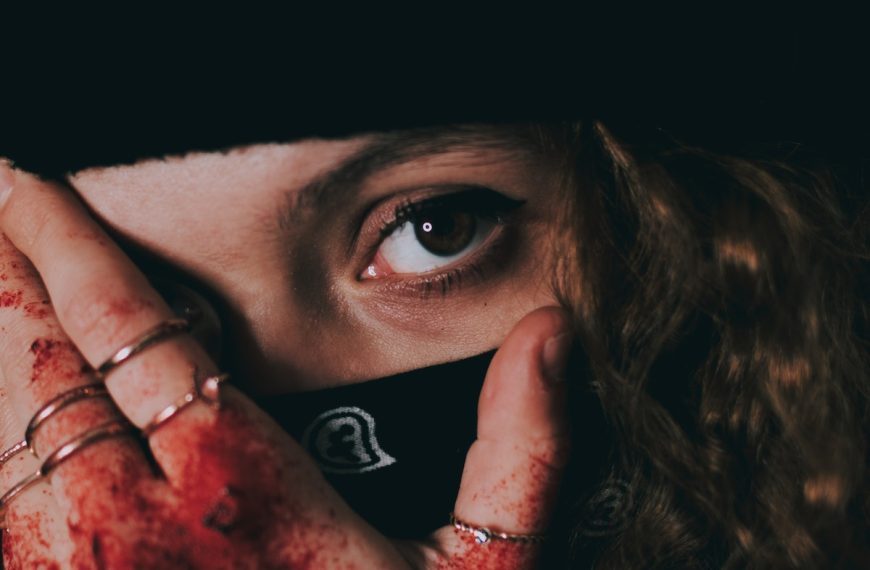 Woman in mask with blood on hand