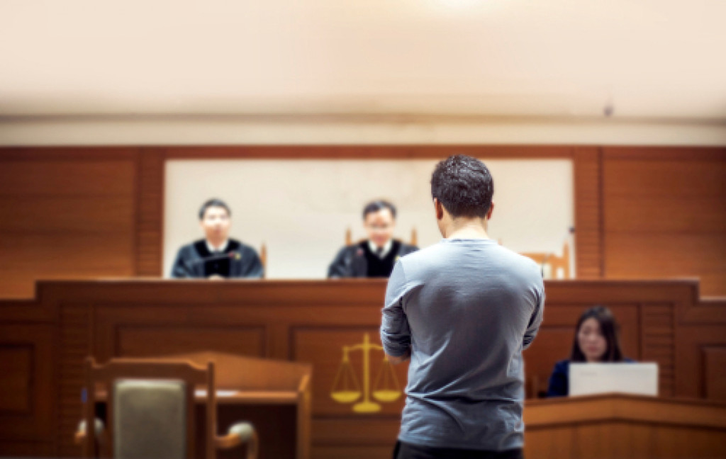 A man facing judges in a court trial